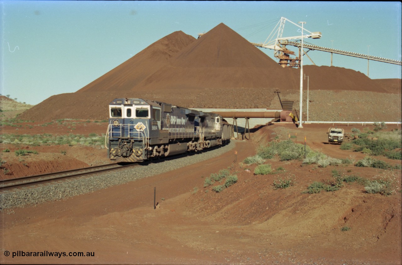 230-24
Yandi Two balloon loop, view of the stockpile area and pedestal stacker, train being loaded at 1.2 km/h behind two Goninan GE CM40-8M rebuilds from different ALCo builders. 5654 'Kashima' serial 8412-11/93-145 is from Comeng ALCo M636 unit 5493 while 5637 'De Grey' serial 8181-01/92-123 is from an AE Goodwin ALCo C636 unit 5456. Geodata [url=https://goo.gl/maps/h68ia1caJvL2] -22.718338, 119.039909 [/url].
Keywords: 5654;Goninan;GE;CM40-8M;8412-11/93-145;rebuild;Comeng-NSW;ALCo;M636C;5493;C6084-9;
