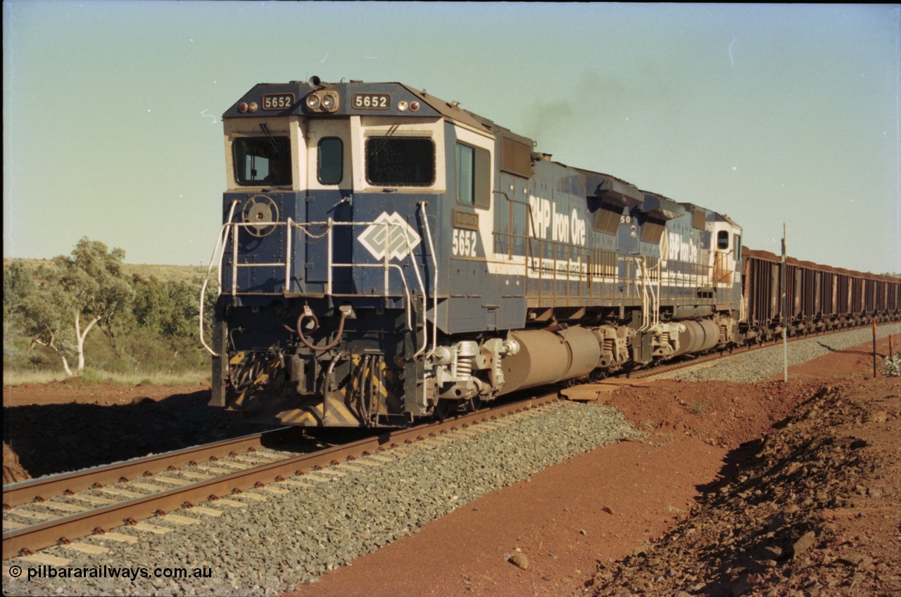 231-35
Yandi Two balloon loop 316.2 km grade crossing, BHP Iron Ore 5652 'Villanueva' serial 8412-09 / 93-143 an Goninan WA rebuild CM40-8M GE unit loads a train at 1.2 km/h with second unit 5650. [url=https://goo.gl/maps/N6VUeKeBS682]GeoData[/url].
Keywords: 5652;Goninan;GE;CM40-8M;8412-09/93-143;rebuild;AE-Goodwin;ALCo;M636C;5482;G6061-3;