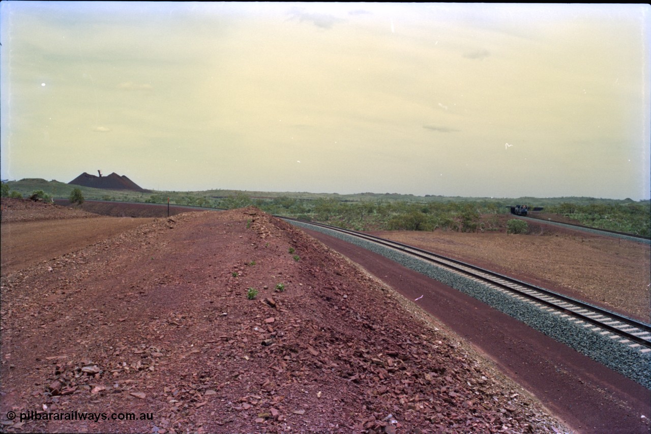 232-03
Yandi Two, view to the stockpile looking west from near the 311.6 km grade crossing. A train can be seen loading on the right. February 1997. [url=https://goo.gl/maps/3tst5WV949N2]GeoData[/url].
