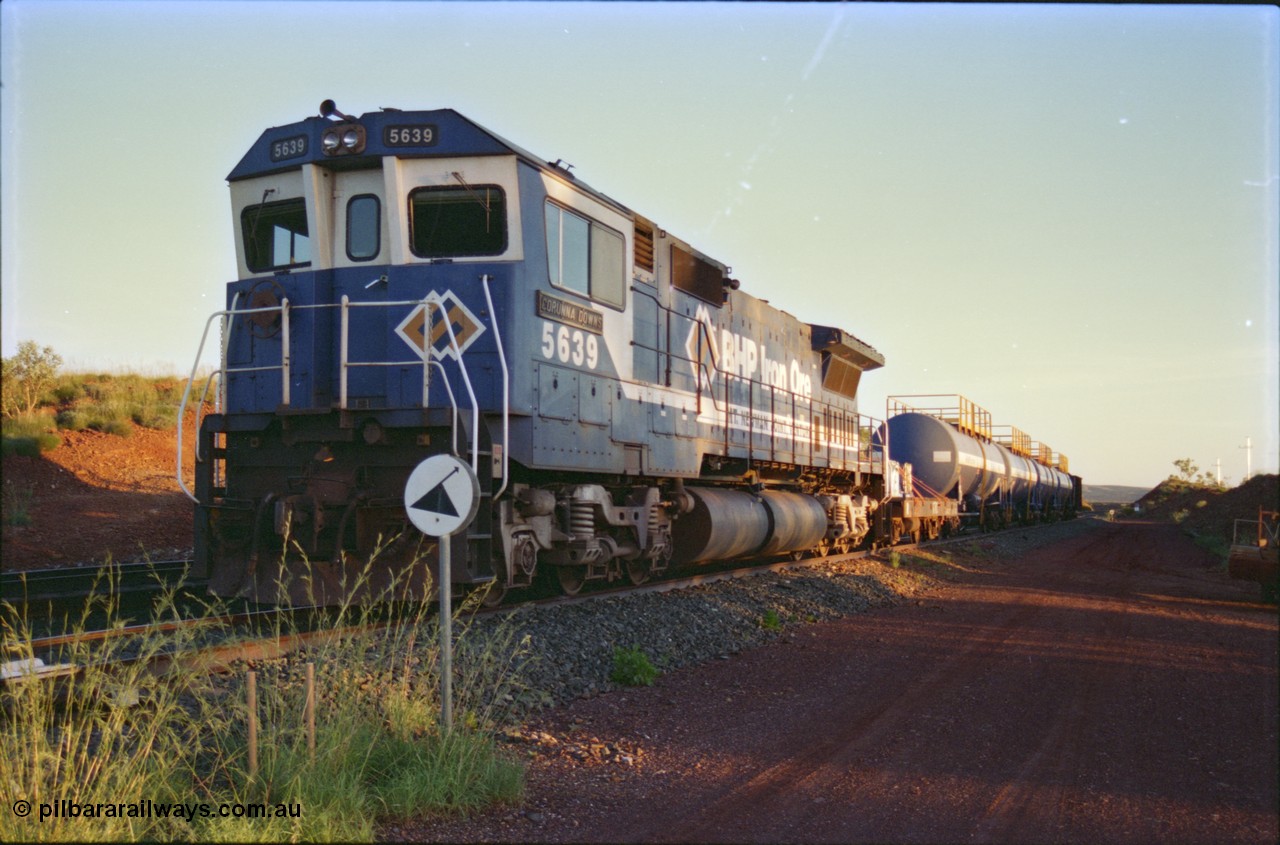 232-10
Yandi One backtrack, following a cyclone shutdown of the mainline and severe flooding around Yandi a 'mixed' freight train was operated to Yandi to deliver food, mail and diesel fuel to the mine and camp. Here BHP Iron Ore CM40-8M unit 5639 'Corunna Downs' serial 8281-03 / 92-128 idles away in the backtrack awaiting its path back to Port Hedland with flat waggon 6703, four fuel tank waggons and a broken ore waggon. February 1997. [url=https://goo.gl/maps/6c1WFqjYSg42]GeoData[/url].
Keywords: 5639;Goninan;GE;CM40-8M;8281-03/92-128;rebuild;AE-Goodwin;ALCo;C636;5459;G6027-3;