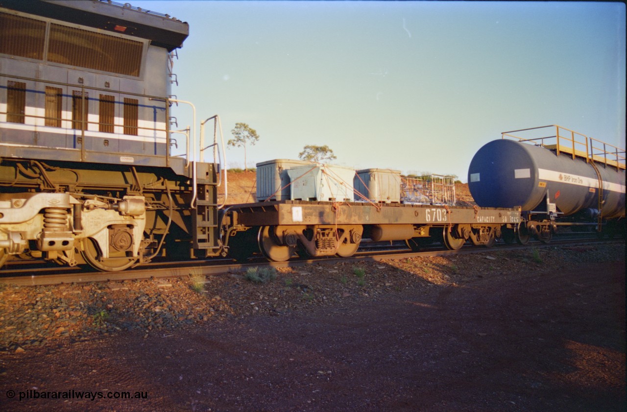 232-13
Yandi One backtrack, following a cyclone shutdown of the mainline and severe flooding around Yandi a 'mixed' freight train was operated to Yandi to deliver food, mail and diesel fuel to the mine and camp. Here BHP Iron Ore 50 ton waggon 6703, one of three 'special' waggons converted from Magor USA built ore waggons by the Mt Newman Workshops. February 1997. [url=https://goo.gl/maps/6c1WFqjYSg42]GeoData[/url].
Keywords: 6703;Mt-Newman-Mining-WS;Magor-USA;