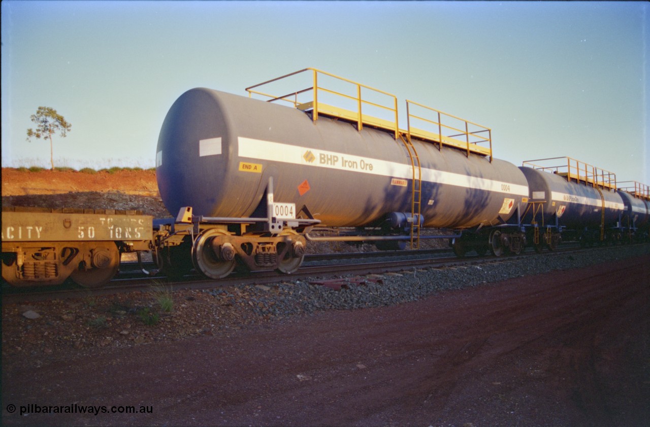 232-15
Yandi One backtrack, following a cyclone shutdown of the mainline and severe flooding around Yandi a 'mixed' freight train was operated to Yandi to deliver food, mail and diesel fuel to the mine and camp. Here BHP Iron Ore empty 82 kL Comeng NSW built tank waggon 0004 one of six such tank waggons built in 1970-71. February 1997. [url=https://goo.gl/maps/6c1WFqjYSg42]GeoData[/url].
Keywords: 0004;Comeng-NSW;BHP-tank-waggon;