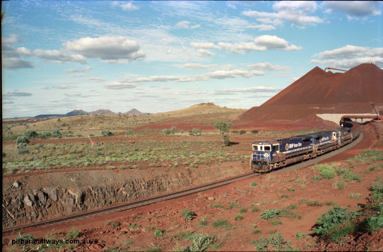 233-26
Yandi Two loaded car side of load-out tunnel, a loading train lead by BHP Iron Ore's Goninan rebuild CM40-8M GE unit 5650 'Yawata' serial 8412-07 / 93-141 as it drags the train around at 1.2 km/h with assistance from two sister units, the end of the 112 waggon or one rake consist can be seen in the middle background. [url=https://goo.gl/maps/gXRbfYH9U482]GeoData[/url].
Keywords: 5650;Goninan;GE;CM40-8M;8412-07/93-141;rebuild;AE-Goodwin;ALCo;M636C;5481;G6061-2;