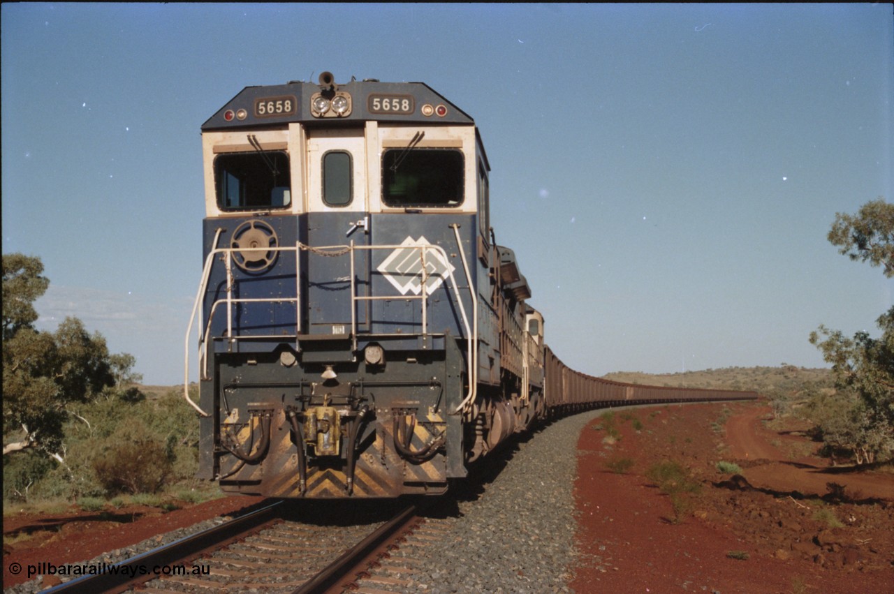234-19
Yandi Two, BHP Iron Ore Goninan rebuild CM40-8M GE unit 5658 'Kakogawa' serial 8412-03 / 94-149 on the front of a 240 waggon loaded train, this configuration was trialled for a time with two Dash 8 locos, 120 waggons, Dash 8, 120 waggons and Dash 8. Circa 1998.
Keywords: 5658;Goninan;GE;CM40-8M;8412-03/94-149;rebuild;AE-Goodwin;ALCo;M636C;5480;G6061-1;