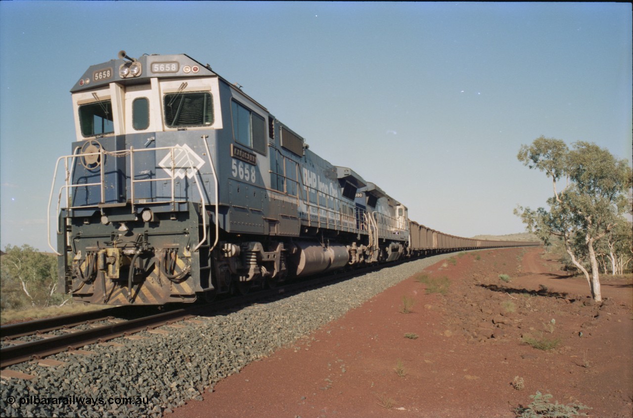 234-29
Yandi Two, BHP Iron Ore Goninan rebuild CM40-8M GE unit 5658 'Kakogawa' serial 8412-03 / 94-149 on the front of a 240 waggon loaded train, this configuration was trialled for a time with two Dash 8 locos, 120 waggons, Dash 8, 120 waggons and Dash 8. Cab front on view. Circa 1998.
Keywords: 5658;Goninan;GE;CM40-8M;8412-03/94-149;rebuild;AE-Goodwin;ALCo;M636C;5480;G6061-1;