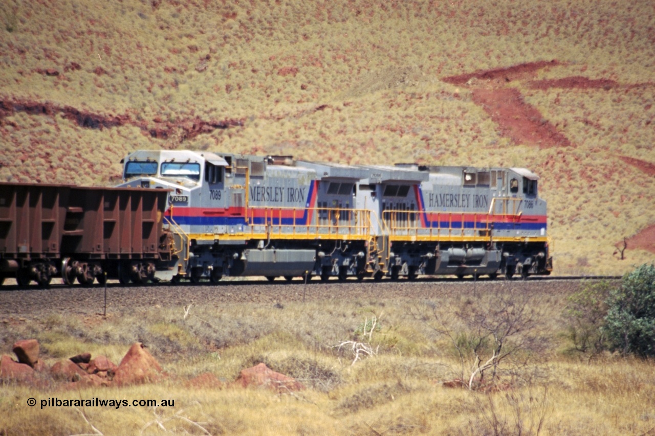 237-31
At the 89 km grade crossing on the Hamersley Iron mainline near Galah Siding, General Electric Dash 9-44CW units 7086 serial 47765 leads 7089 serial 47768 as they struggle up the grade with empty train.
