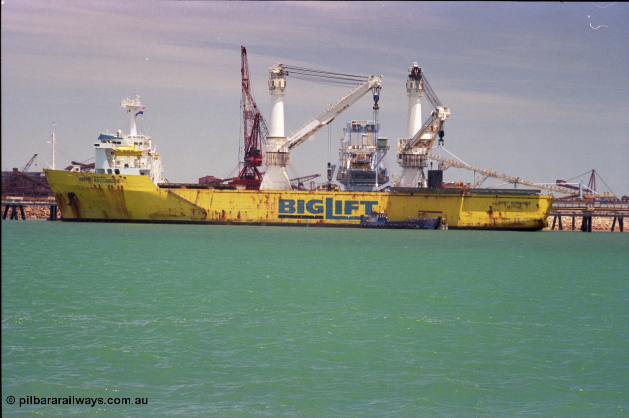 238-03
Port Hedland Harbour, heavy lift ship Happy Buccaneer (IMO: 8300389) sits at Finucane Island D Berth delivering a new shiploader for BHP Billiton. 1st November 2003. [url=https://goo.gl/maps/vWZoHTsRPsp] Geodata [/url]. Back in time here the ship cranes were only 550 tonne each, these are now 700.
Keywords: Happy-Buccaneer;Hitachi-Shipbuilding-Osaka-Japan;