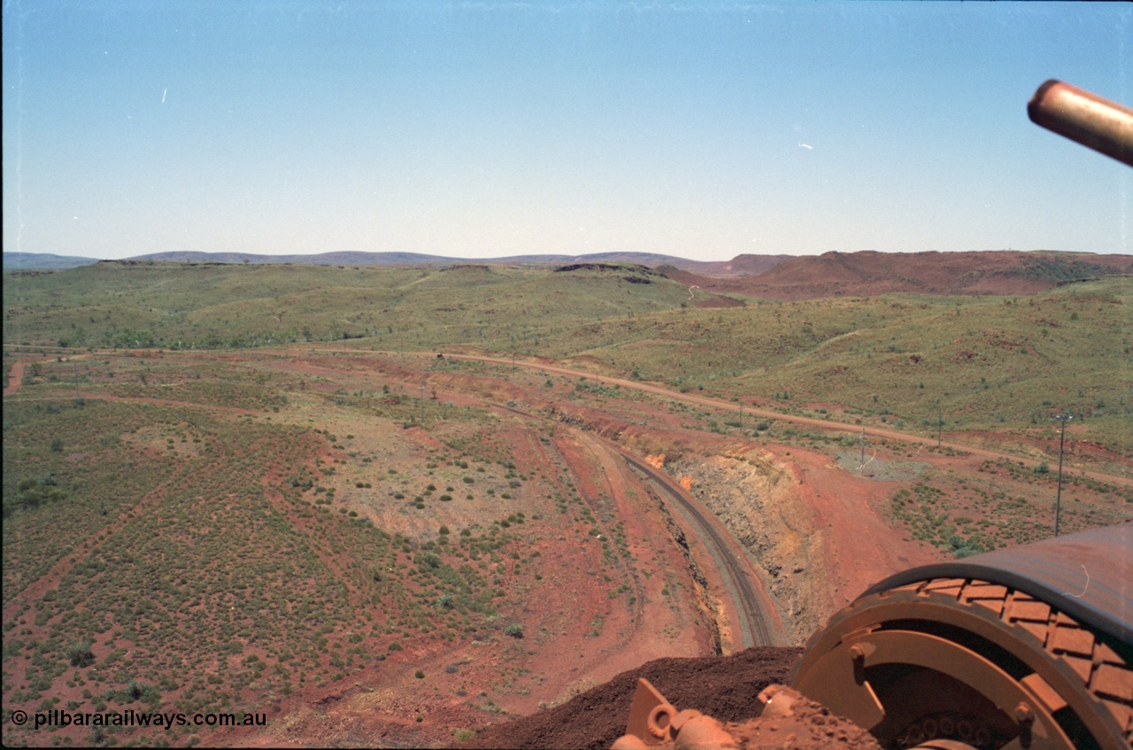 239-07
View from the Yandi One radial stacker looking north east, the camp for the mine is located a couple of kilometres beyond those front hills. The head drum of the conveyor and the ore stockpile are visible in the corner. [url=https://goo.gl/maps/hApNXoLtbtQ2]GeoData[/url].
