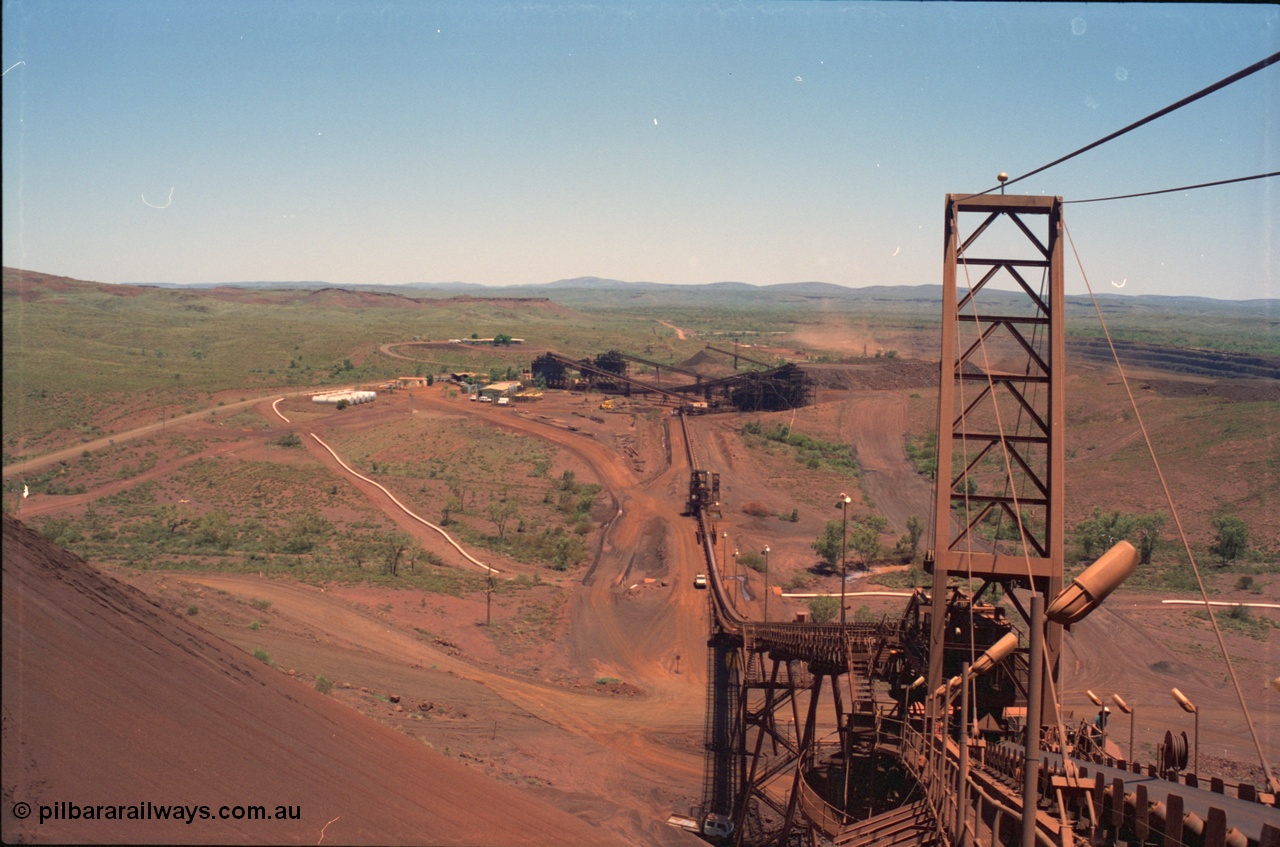 239-09
Overview of Yandi One mine from the end of the radial stacker boom looking south. Buildings visible from the left, diesel fuel farm, sample hut, workshops beyond the power station and the offices in the background. [url=https://goo.gl/maps/hApNXoLtbtQ2]GeoData[/url].
