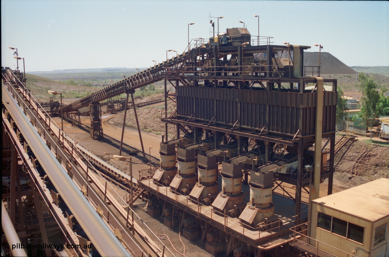 239-18
View of Yandi One OHP looking from the secondary crusher north east at the 'old side' bank of five tertiary crushers. The control room is in the bottom right corner and glimpses of the stockpile and power station and offices can be seen on the right. CV6 is running up the left of the image to the middling crushers. [url=https://goo.gl/maps/gpgfApaAJYt]GeoData[/url].

