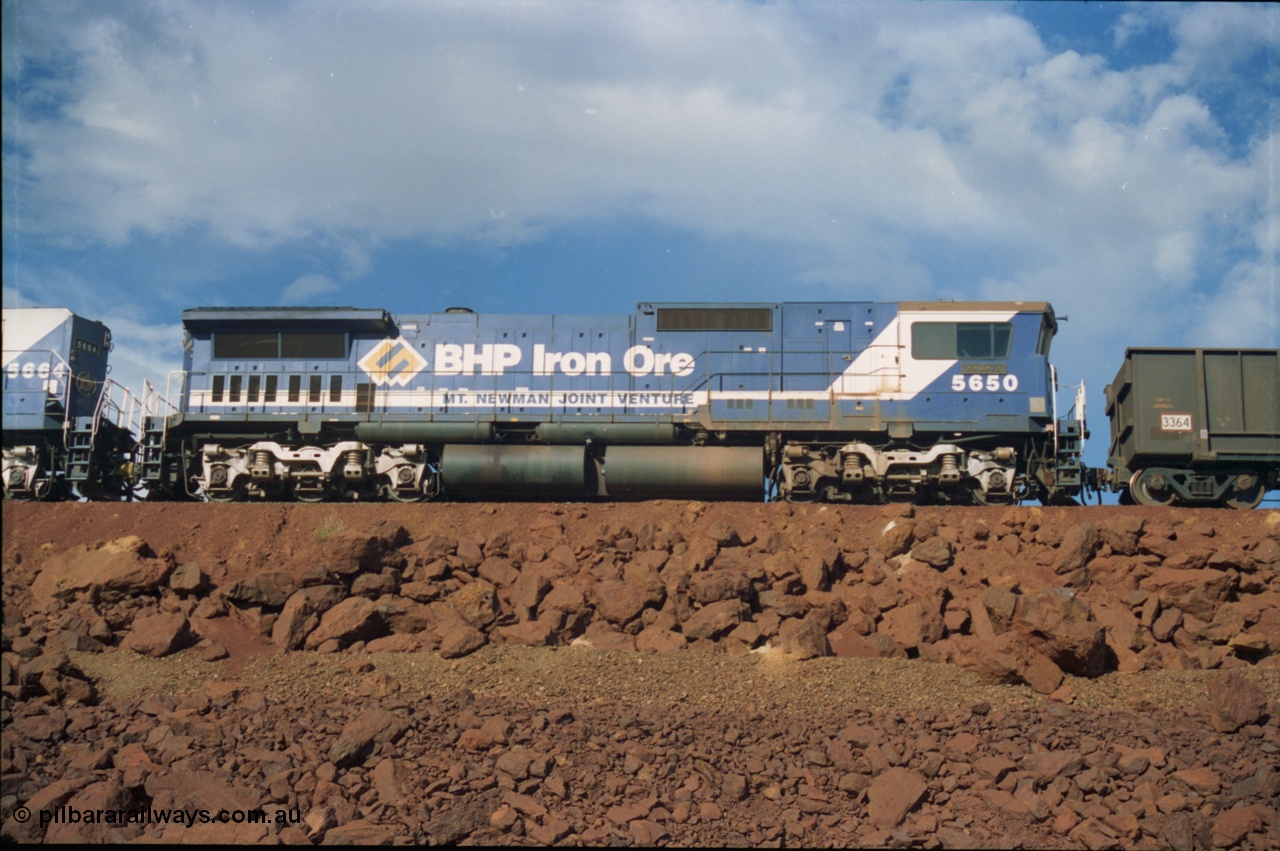 239-24
Yandi One balloon loop sees the 1600 empty arrival with mid-train locomotive 5650 'Yawata', a Goninan rebuild GE CM40-8M model serial no. 8412-07/93-141 edging towards the load-out tunnel on the 17/01/1997. [url=https://goo.gl/maps/hPivRh6qE8R2]GeoData[/url].
Keywords: 5650;Goninan;GE;CM40-8M;8412-07/93-141;rebuild;AE-Goodwin;ALCo;M636C;5481;G6061-2;