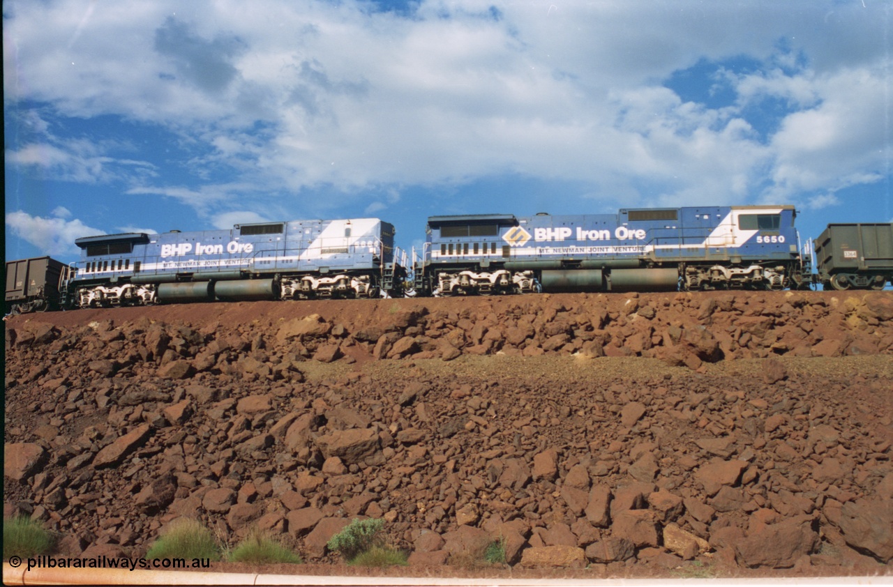 239-26
Yandi One balloon loop sees the 1600 empty arrival with mid-train locomotives 5650 'Yawata', a Goninan rebuild GE CM40-8M model serial no. 8412-07/93-141 with a LocoTrol equipped Goninan rebuild CM40-8ML cab-less unit, serial no. 8412-09/94-155 5664 'Kaohsiung' edging towards the load-out tunnel on the 17/01/1997. [url=https://goo.gl/maps/hPivRh6qE8R2]GeoData[/url].
Keywords: 5650;Goninan;GE;CM40-8M;8412-07/93-141;rebuild;AE-Goodwin;ALCo;M636C;5481;G6061-2;