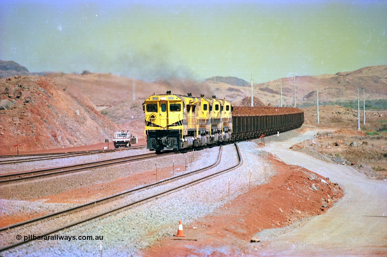 246-14
Cape Lambert, yard view of the then new extension to the south for the West Angelas mine was coming on stream as a Robe River loaded Deepdale train arrives on the main behind the standard quad Dash 8 power with 202 waggons. 9414 which is a Goninan WA ALCo to GE rebuild CM40-8M with serial 8206-11 / 91-124 from November 1991 and was originally an AE Goodwin built M636 ALCo built new for Robe in December 1971 and numbered 262.005, later numbered 1714. 22nd May 2002.
Keywords: 9414;Goninan;GE;CM40-8M;8206-11/91-124;rebuild;AE-Goodwin;ALCo;M636;G6060-5;