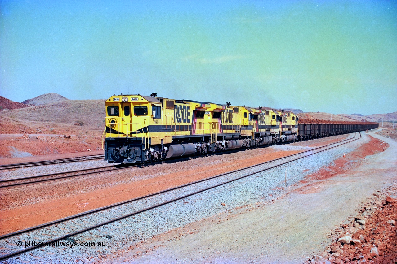 246-18
Cape Lambert, yard view of the then new extension to the south for the West Angelas mine was coming on stream as a Robe River loaded Deepdale train arrives on the main behind the standard quad Dash 8 power with 202 waggons. 9414 which is a Goninan WA ALCo to GE rebuild CM40-8M with serial 8206-11 / 91-124 from November 1991 and was originally an AE Goodwin built M636 ALCo built new for Robe in December 1971 and numbered 262.005, later numbered 1714. 22nd May 2002.
Keywords: 9414;Goninan;GE;CM40-8M;8206-11/91-124;rebuild;AE-Goodwin;ALCo;M636;G6060-5;