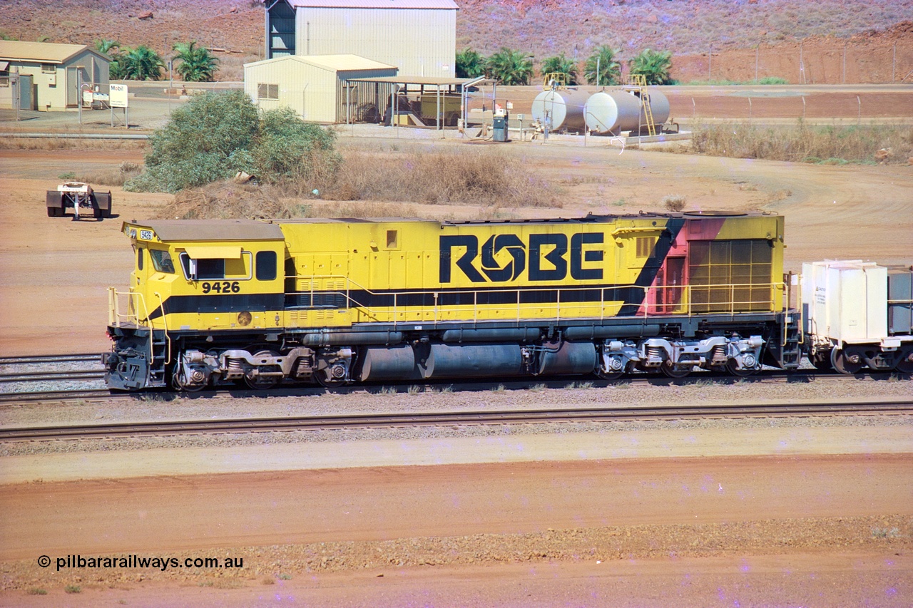 247-10
Cape Lambert, Robe River's 9426 a Comeng WA rebuild from ALCo Schenectady NY model C636 serial 3499-3 originally built in January 1968 for Pennsylvania as #6332, Penn Central 6332 and finally Conrail 6782. Purchased in 1986 and rebuilt by Comeng WA into C636R before delivery to Robe in November 1986. This loco also went on to become DR 8401 for construction of FMG's railway in 2007-08. Seen here in the South Yard dragging a loaded rake down to the car dumper. Approximate location of train is [url=https://goo.gl/maps/L8Y75jkpyVdps6pg6]here[/url]. 22nd May 2002.
Keywords: 9426;Comeng-WA;C636R;WA143-1;rebuild;ALCo;Schenectady-NY;C636;Conrail;6782;3499-3;