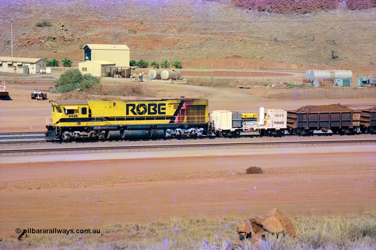 247-11
Cape Lambert, Robe River's 9426 a Comeng WA rebuild from ALCo Schenectady NY model C636 serial 3499-3 originally built in January 1968 for Pennsylvania as #6332, Penn Central 6332 and finally Conrail 6782. Purchased in 1986 and rebuilt by Comeng WA into C636R before delivery to Robe in November 1986. This loco also went on to become DR 8401 for construction of FMG's railway in 2007-08. Seen here in the South Yard dragging a loaded rake down to the car dumper. Approximate location of train is [url=https://goo.gl/maps/L8Y75jkpyVdps6pg6]here[/url]. 22nd May 2002.
Keywords: 9426;Comeng-WA;C636R;WA143-1;rebuild;ALCo;Schenectady-NY;C636;Conrail;6782;3499-3;