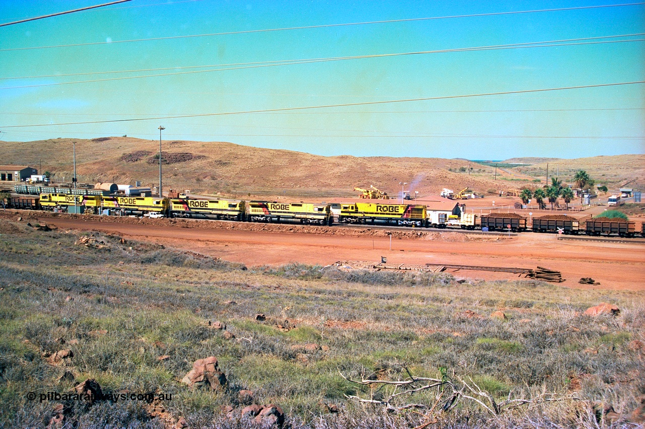 247-21
Cape Lambert yard view with Robe River Comeng WA ALCo Schenectady NY model rebuild C636R unit 9426 dragging a loaded 101 waggon rake from the South Yard across Bells Crossing while a brace of four Goninan CM40-8M GE rebuilds wait at the fuel point for a departure with an empty train. Approximate location of photo is [url=https://goo.gl/maps/TvJoLDjReJ2xoob69]here[/url]. 22nd May 2002.
Keywords: 9426;Comeng-WA;C636R;WA143-1;rebuild;ALCo;Schenectady-NY;C636;Conrail;6782;3499-3;