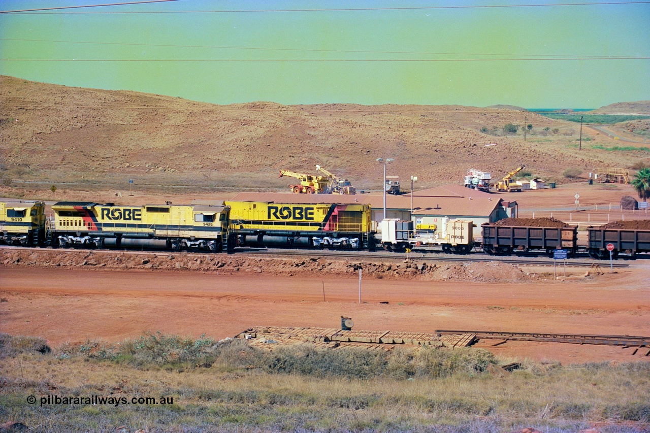 247-22
Cape Lambert yard view with Robe River Comeng WA ALCo Schenectady NY model rebuild C636R unit 9426 dragging a loaded 101 waggon rake from the South Yard across Bells Crossing while a brace of four Goninan CM40-8M GE rebuilds wait at the fuel point for a departure with an empty train. Approximate location of photo is [url=https://goo.gl/maps/TvJoLDjReJ2xoob69]here[/url]. 22nd May 2002.
Keywords: 9426;Comeng-WA;C636R;WA143-1;rebuild;ALCo;Schenectady-NY;C636;Conrail;6782;3499-3;