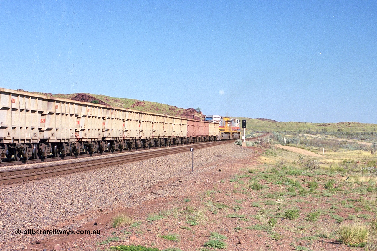 248-14
Dingo Siding on the Hamersley Iron railway at the 39 km with an empty train headed up by a pair of General Electric built Dash 9-44CW units 7077 serial 47756 from the original first order in the Pepsi Can livery and 9408 serial 54158 from the fourth order in the Pilbara Rail livery with Robe ownership markings powers away to the south back onto the mainline with the signal marker board DI19 for Dingo 19. Approximate [url=https://goo.gl/maps/Jv752bD5KXv28oUV7]location[/url]. 24th April 2004.
