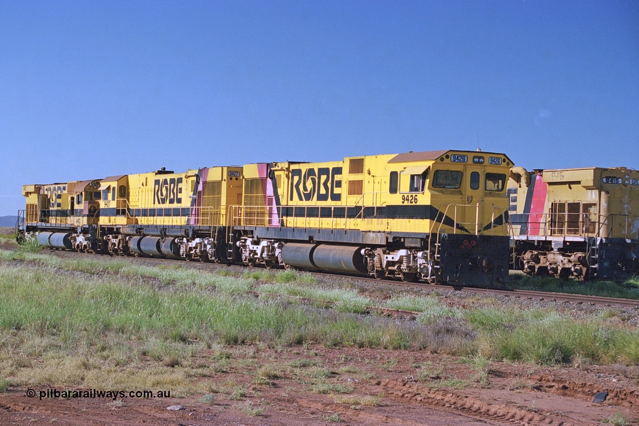 248-16
Seven Mile yard, stored Robe River ALCo locomotives at the south end of the Hamersley Iron Seven Mile yard on roads N2 and N3. On road N2 is 9426 a Comeng WA C636R rebuild from ALCo Schenectady NY model C636 serial 3499-3 originally built in January 1968 for Pennsylvania Railroad as #6332, Penn Central 6332 and finally Conrail 6782. Purchased in 1986 and rebuilt by Comeng WA into C636R before delivery to Robe in November 1986. This loco also went on to become DR 8401 for construction of FMG's railway in 2007-08. Behind it is sister unit 9427 and ALCo M636 9412. Approximate [url=https://goo.gl/maps/CXwAreRPb2RymQ9m9]location[/url]. 24th April 2004.
Keywords: 9426;Comeng-WA;C636R;WA143-1;rebuild;ALCo;Schenectady-NY;C636;Conrail;6782;3499-3;