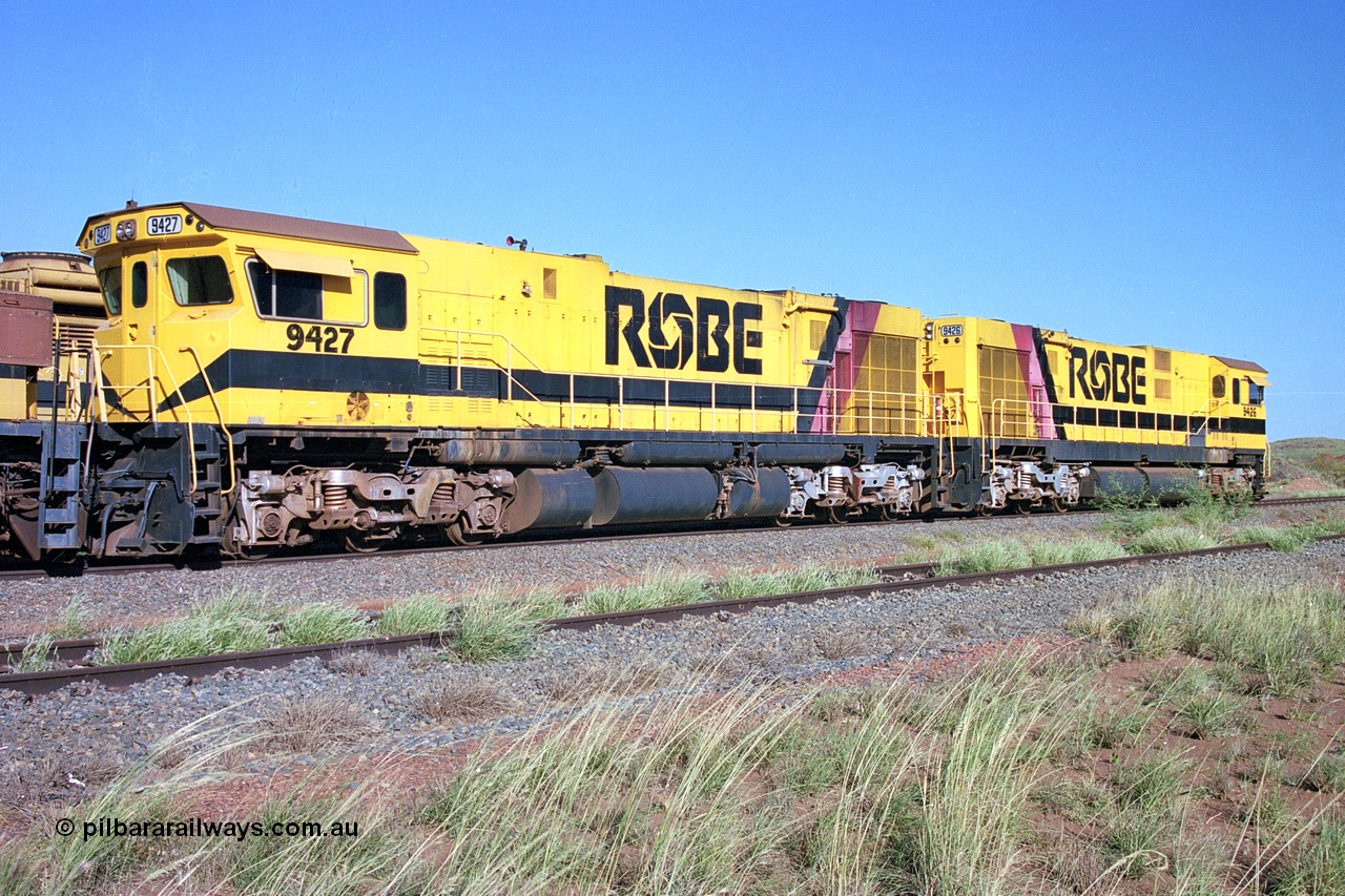 248-18
Seven Mile yard, stored Robe River ALCo locomotives at the south end of the Hamersley Iron Seven Mile yard on roads N2 and N3. On road N2 is 9427 a Comeng WA C636R rebuild from ALCo Schenectady NY model C636 serial 3499-2 originally built in January 1968 for Pennsylvania Railroad as #6331, Penn Central 6331 and finally Conrail 6781. Purchased in 1986 and rebuilt by Comeng WA into C636R before delivery to Robe in January 1987. This loco also went on to become DR 8403 for construction of FMG's railway in 2007-08. Behind it is sister unit 9426. Approximate [url=https://goo.gl/maps/CXwAreRPb2RymQ9m9]location[/url]. 24th April 2004.
Keywords: 9427;Comeng-WA;C636R;WA143-2;rebuild;ALCo;Schenectady-NY;C636;Conrail;6781;3499-2;