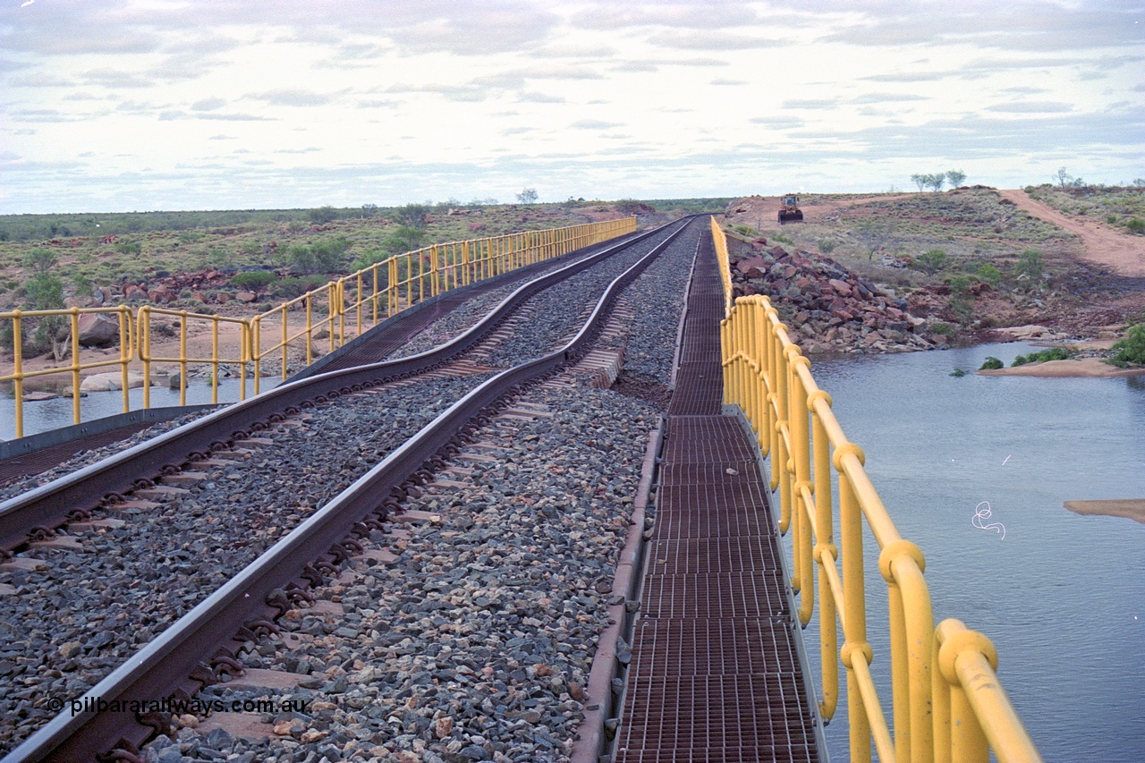 249-12
Yule River bridge looking north from the bridge deck on the BHP mainline of the sunk track section. The third pier from the southern end was undermined by flood waters from Tropical Cyclone John in December 1999. The rail line was closed for two weeks while repairs were effected. Approximate [url=https://goo.gl/maps/phCWr8u1xnuBdzwj6]location[/url].
