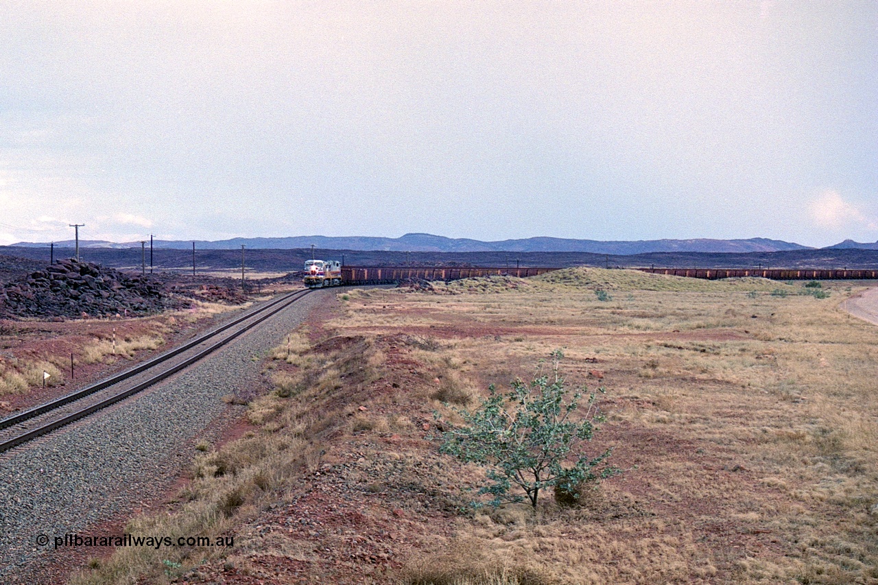 249-27
A loaded Hamersley Iron train runs across the plains north of Dugite Siding near the 70 km as it nears the destination of its cargo. Approximate [url=https://goo.gl/maps/UUfj15vTkvBaPCaw8]location[/url]. 18th December 1999.
