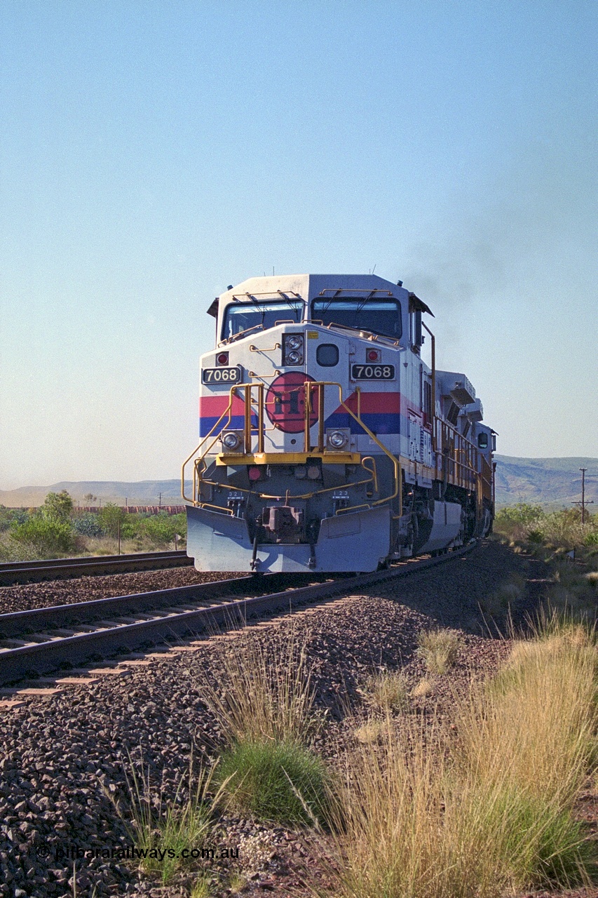250-17
Pelican Siding on the Hamersley Iron Tom Price line about the 208 km with an empty train behind the standard pairing of two General Electric built 9-44CW units 7068 serial 47747 and 7067 serial 47746 stand on the loop or passing track for a meet with a loaded train. 1550 hrs 21st October 2000.
Keywords: 7068;GE;Dash-9-44CW;47747;
