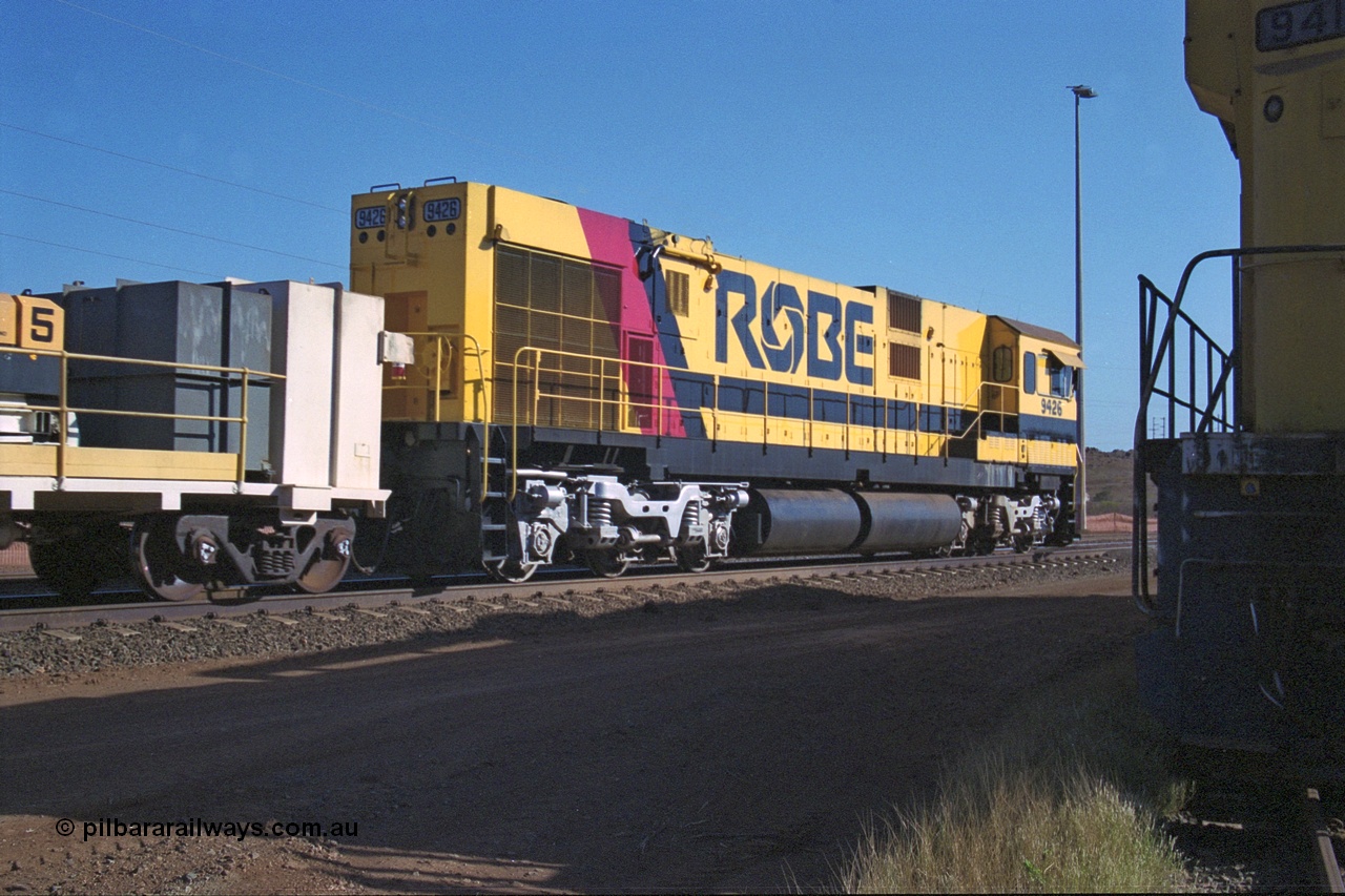 250-26
Cape Lambert South Yard and Robe River's 9426 a Comeng WA rebuild from ALCo Schenectady NY model C636 serial 3499-3 originally built in January 1968 for Pennsylvania as #6332, Penn Central 6332 and finally Conrail 6782. Purchased in 1986 and rebuilt by Comeng WA into C636R before delivery to Robe in November 1986. This loco also went on to become DR 8401 for construction of FMG's railway in 2007-08. Seen here in the South Yard dragging a loaded rake down to the car dumper. 22nd October 2000.
Keywords: 9426;Comeng-WA;C636R;WA143-1;rebuild;ALCo;Schenectady-NY;C636;Conrail;6782;3499-3;
