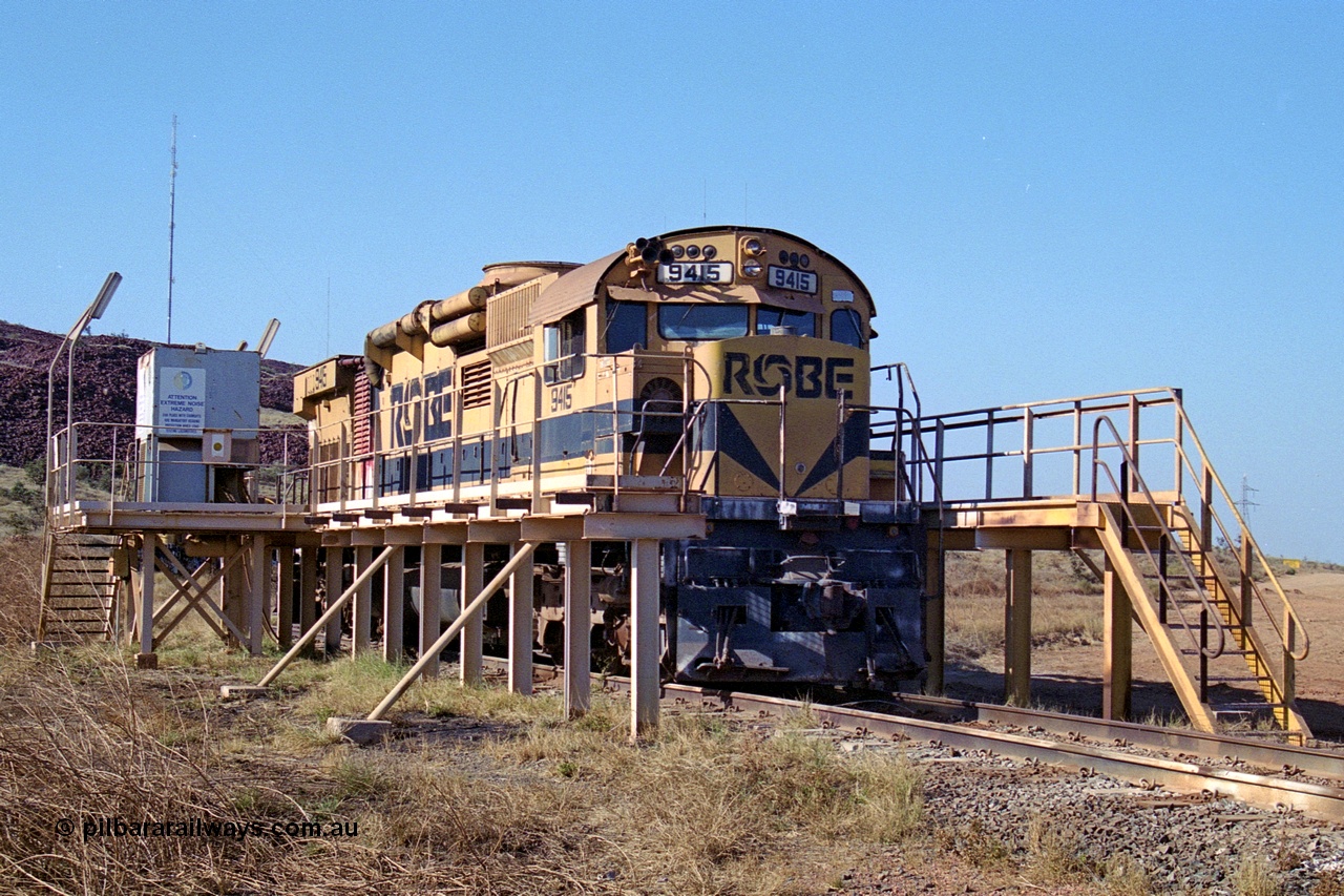 250-30
Cape Lambert yard in the Load Box is recently stored Robe River AE Goodwin built ALCo M636 unit 9415 serial G6060-6 from February 1973 and was an extension of the original order and delivered with cab side numbering of 86-14-1715 and number boards as 1715. The ducting on the hood is the air to air intercooler modifications. 22nd October 2000.
Keywords: 9415;AE-Goodwin;MLW-ALCo;M636;G6060-6;