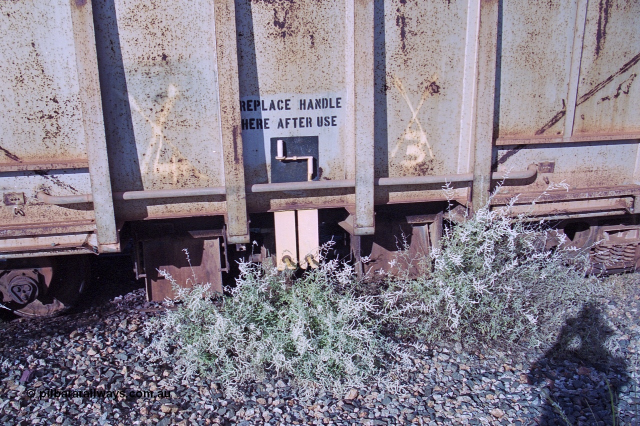 251-34
Bing Siding, BHP ballast waggon 509 sits in a dead end siding very much unloved. View of the ballast discharge chutes and the manual handle. Originally an ore waggon and built by Magor USA and was one of the original fleet of waggons to come out to WA with the car dumper at the beginning of the Mt Newman project. 22nd April 2000.
Keywords: Magor-USA;BHP-ballast-waggon;