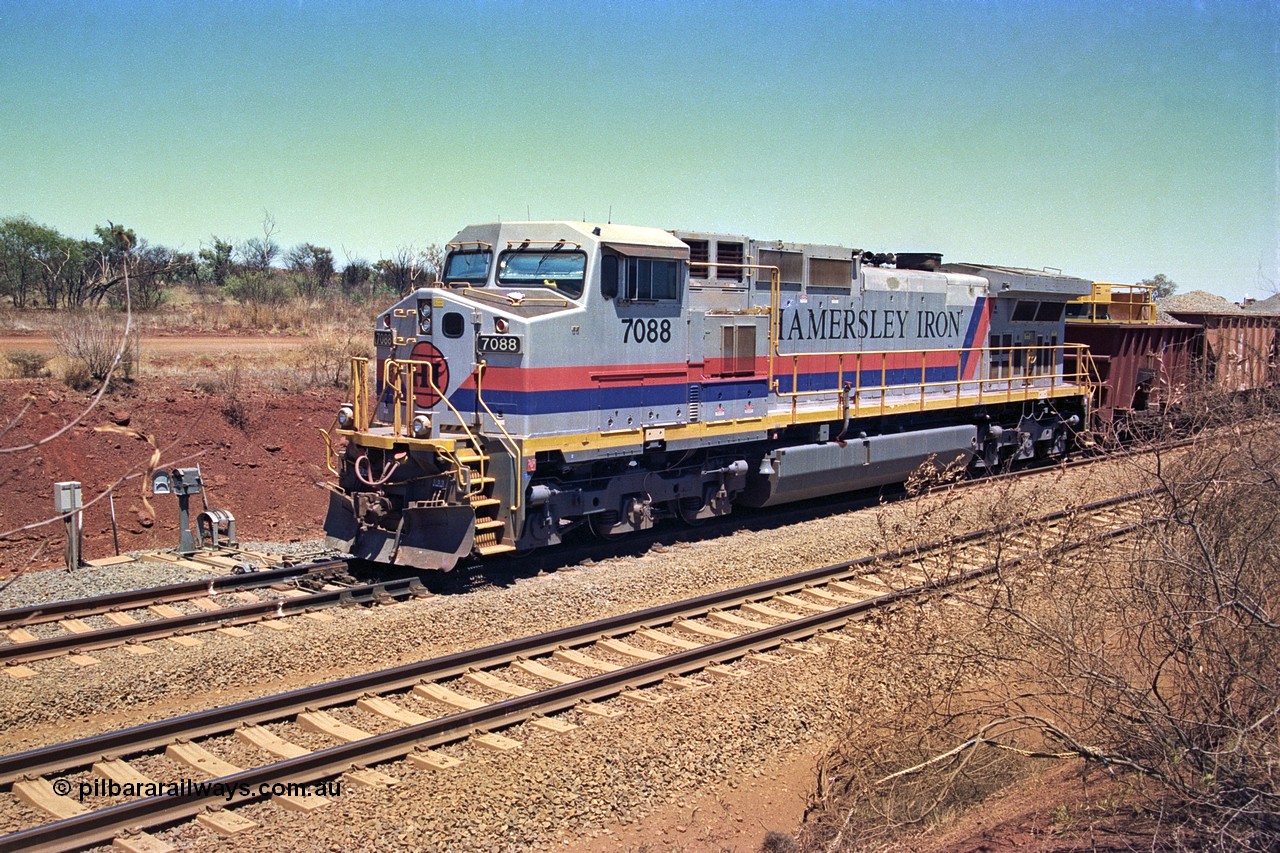 252-04
Cockatoo Siding 273 km on the Hamersley Iron line to Yandi, General Electric built 9-44CW unit 7088 with serial number 47767 from the original 1994 build idles away on the eastern end of the ballast train as it is loaded and slowly progresses into the back track siding Ballast plough BP 02 is behind the locomotive. Location is roughly [url=https://goo.gl/maps/bCvLZxMc1z57F8ym9]here[/url]. 24th November 2001.
Keywords: 7088;GE;Dash-9-44CW;47767;