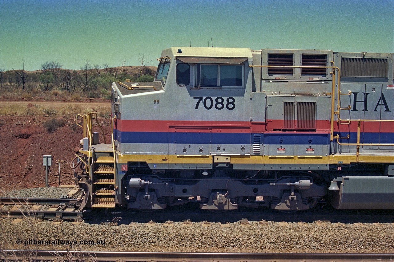 252-07
Cockatoo Siding 273 km on the Hamersley Iron line to Yandi, General Electric built 9-44CW unit 7088 with serial number 47767 from the original 1994 build idles away on the eastern end of the ballast train. Cab side view. Location is roughly [url=https://goo.gl/maps/bCvLZxMc1z57F8ym9]here[/url]. 24th November 2001.
Keywords: 7088;GE;Dash-9-44CW;47767;