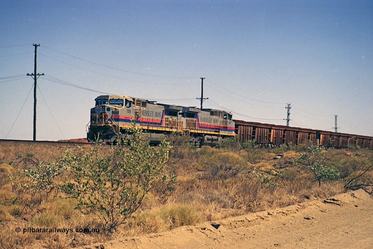 253-03
Dugite near the 64 km on the Dampier - Tom Price railway, a loaded Hamersley Iron train headed up by General Electric 9-44CW units 7078, from the original order, serial number 47757 and 7096, from the second order, serial number 52843 arrive taking the mainline to cross an empty which is in the passing track.
Keywords: 7078;GE;Dash-9-44CW;47757;