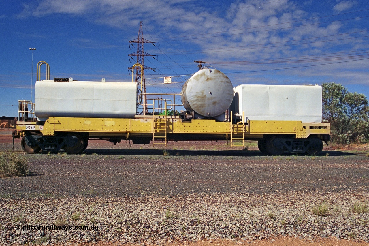 253-35
Nelson Point hard stand area, riveted flat waggon 202 with three water tanks fitted, side profile view, originally part of the 'camp train', modified by Mt Newman Mining railway workshops.
Keywords: BHP-flat-waggon;