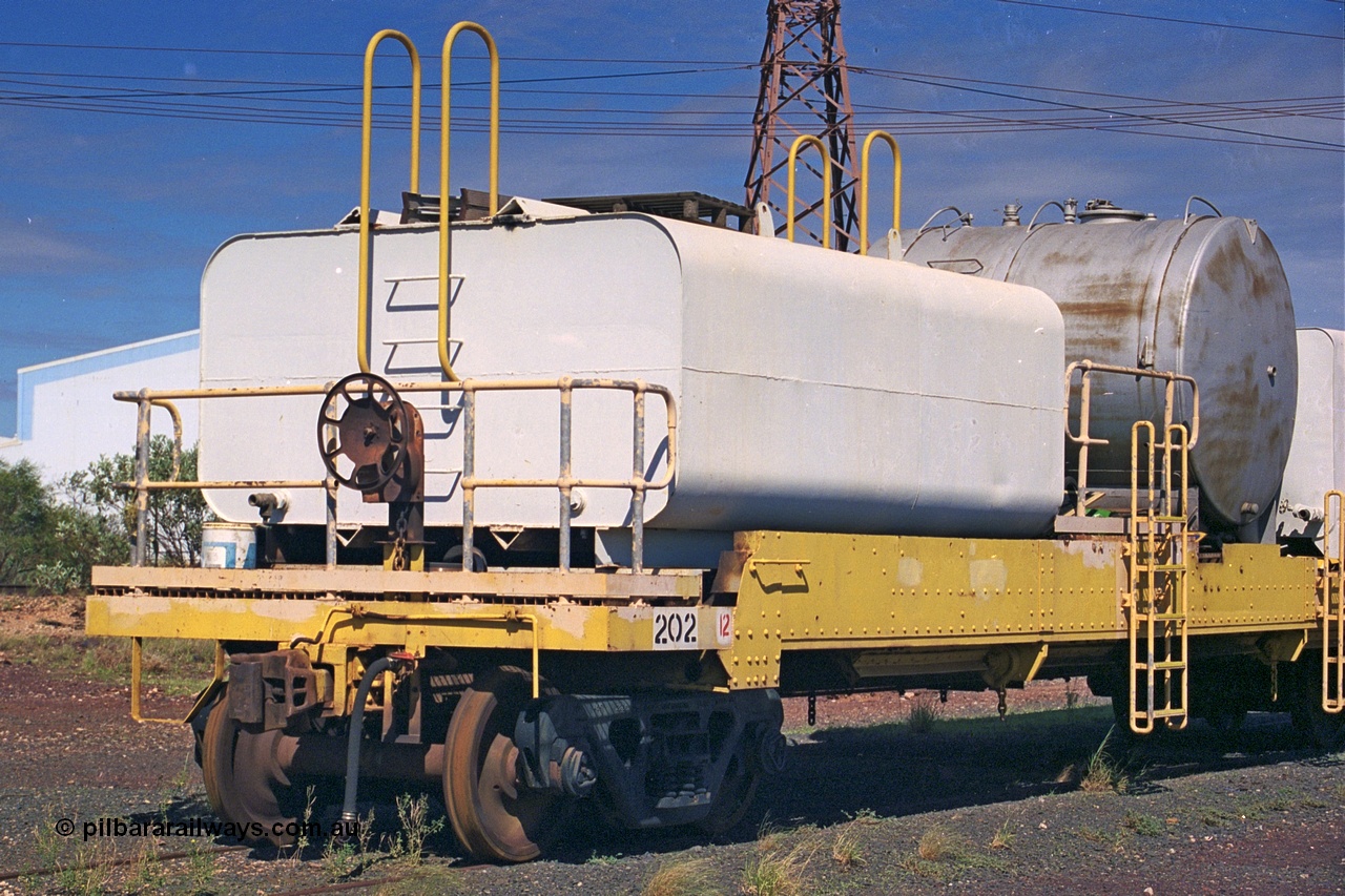 253-37
Nelson Point hard stand area, riveted flat waggon 202 with three water tanks fitted, view of handbrake end, originally part of the 'camp train', modified by Mt Newman Mining railway workshops.
Keywords: BHP-flat-waggon;