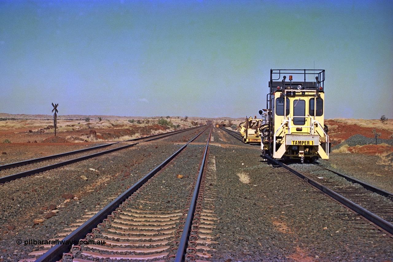 255-05
Siding Three looking south across the 133.3 km grade crossing with Tamper 1 and a sleeper inserter machine stabled in the back track. Both machines are Fairmont Tamper units. Geodata [url=https://goo.gl/maps/hn7S75CkAm2jmAuC9]location here[/url]. May 2002.
