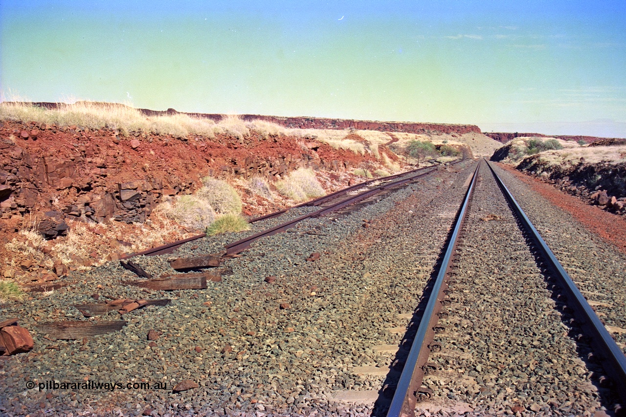 255-11
At the 162.2 km looking south are the remains of the second Robe River loadout facility which was installed in 1975 to mine the Mesa 2402E mining area, the line was a four kilometre U shaped spur. Geodata [url=https://goo.gl/maps/DATgFuHfuayyAp8y9]location here[/url]. May 2002.
