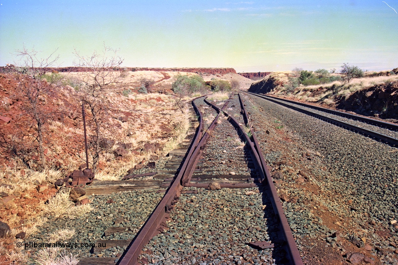 255-12
At the 162.2 km looking south are the remains of the second Robe River loadout facility which was installed in 1975 to mine the Mesa 2402E mining area, the line was a four kilometre U shaped spur. Geodata [url=https://goo.gl/maps/DATgFuHfuayyAp8y9]location here[/url]. May 2002.
