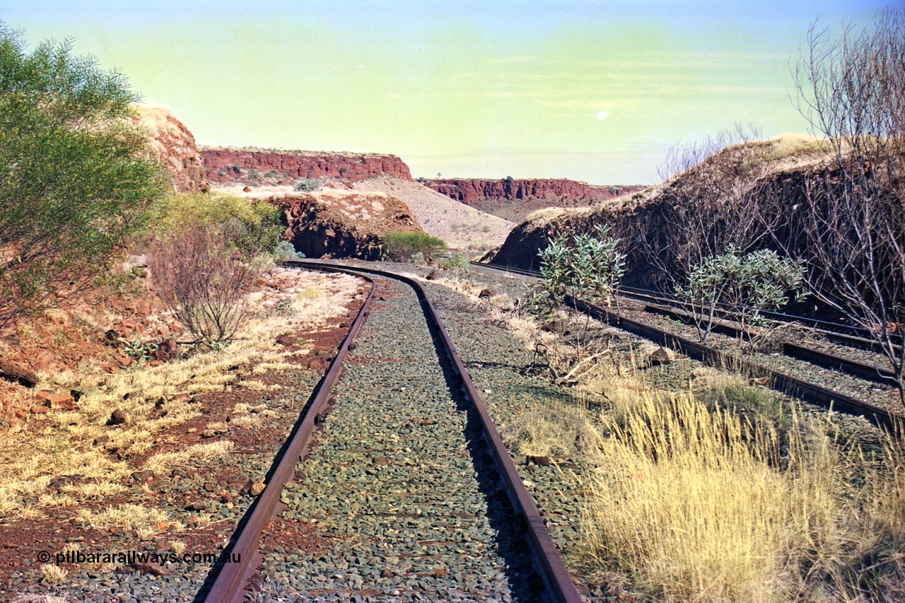 255-13
At the 162.2 km looking south are the remains of the second Robe River loadout facility which was installed in 1975 to mine the Mesa 2402E mining area, the line was a four kilometre U shaped spur. The Deepdale line is on the right. Geodata [url=https://goo.gl/maps/DATgFuHfuayyAp8y9]location here[/url]. May 2002.
