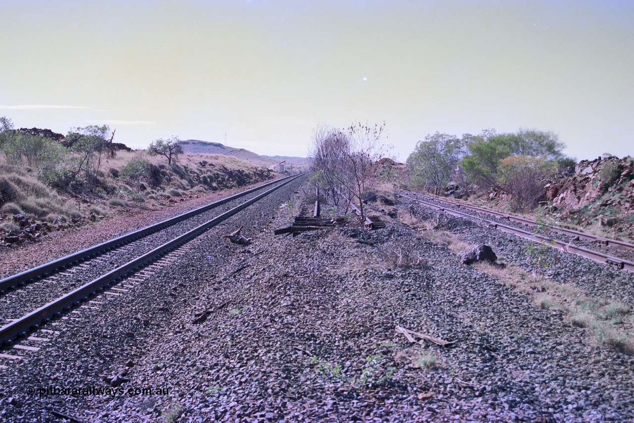 255-15
At the 162.2 km looking north are the remains of the second Robe River loadout facility which was installed in 1975 to mine the Mesa 2402E mining area, the line was a four kilometre U shaped spur. The Deepdale lone is on the left while the spur runs behind the photographer and curves away from the Deepdale line. Geodata [url=https://goo.gl/maps/DATgFuHfuayyAp8y9]location here[/url]. May 2002.
