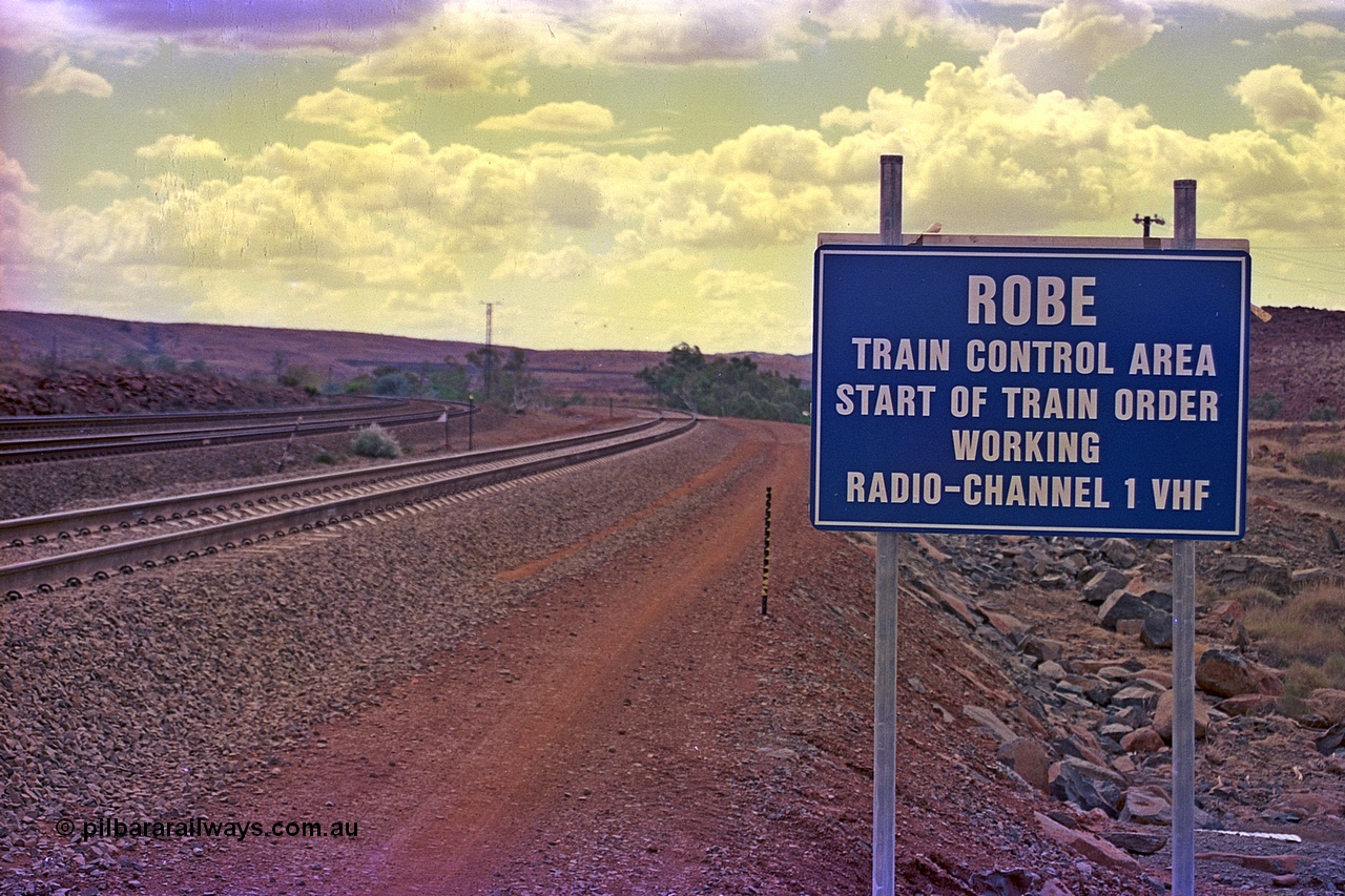 255-34
Emu Siding on the Hamersley Iron Dampier to Tom Price line with the Western Creek Robe River interconnecting line on the right heading around to join the Cape Lambert to Deepdale line. Train Control board for crews to change channels. May 2002.
