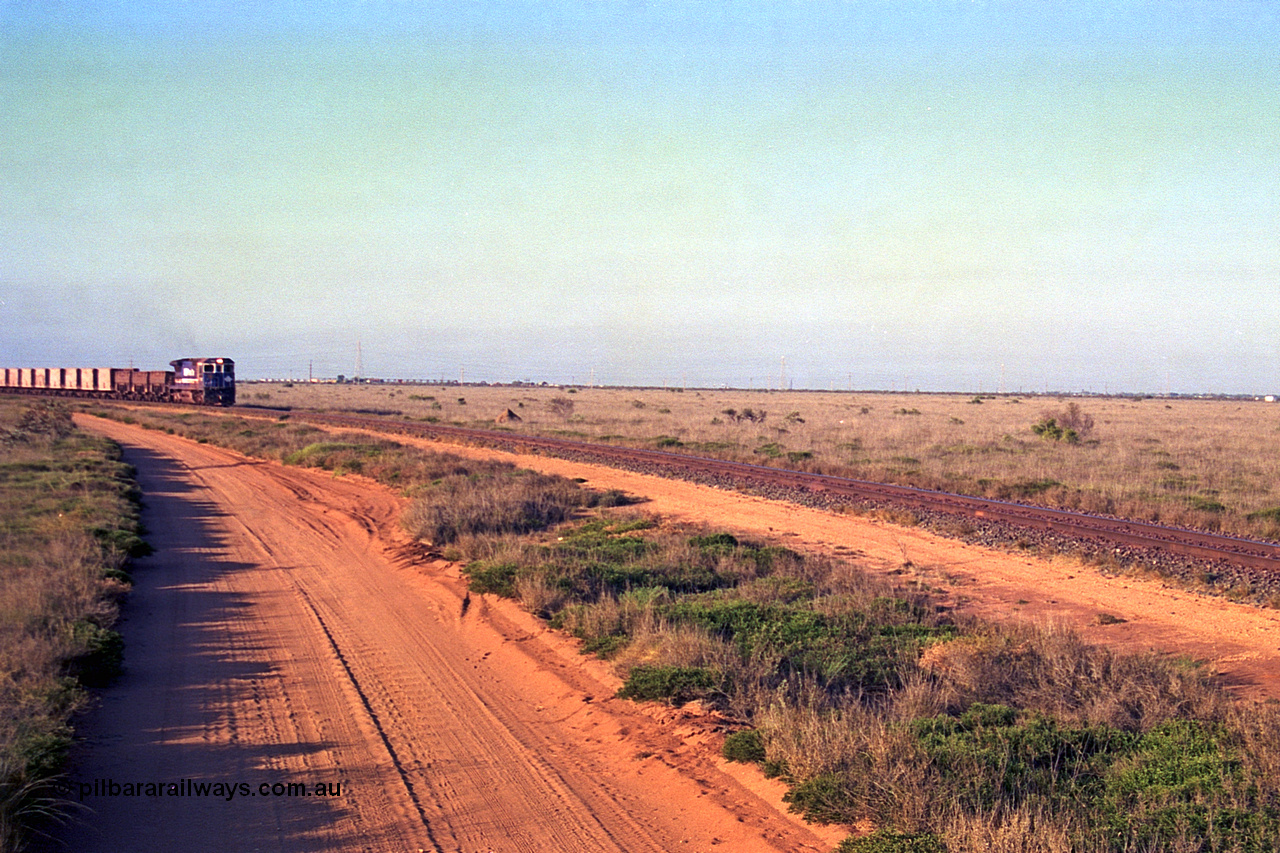 257-23
Goldsworthy Junction, an empty train runs between the junction and the Broome Rd crossing behind the standard single locomotive 5646 'White Springs', a Goninan 1992 built GE CM40-8 model with serial number 5244-11 / 92-135. Late 2001.
Keywords: 5646;Goninan;GE;CM40-8;8244-11/92-135;