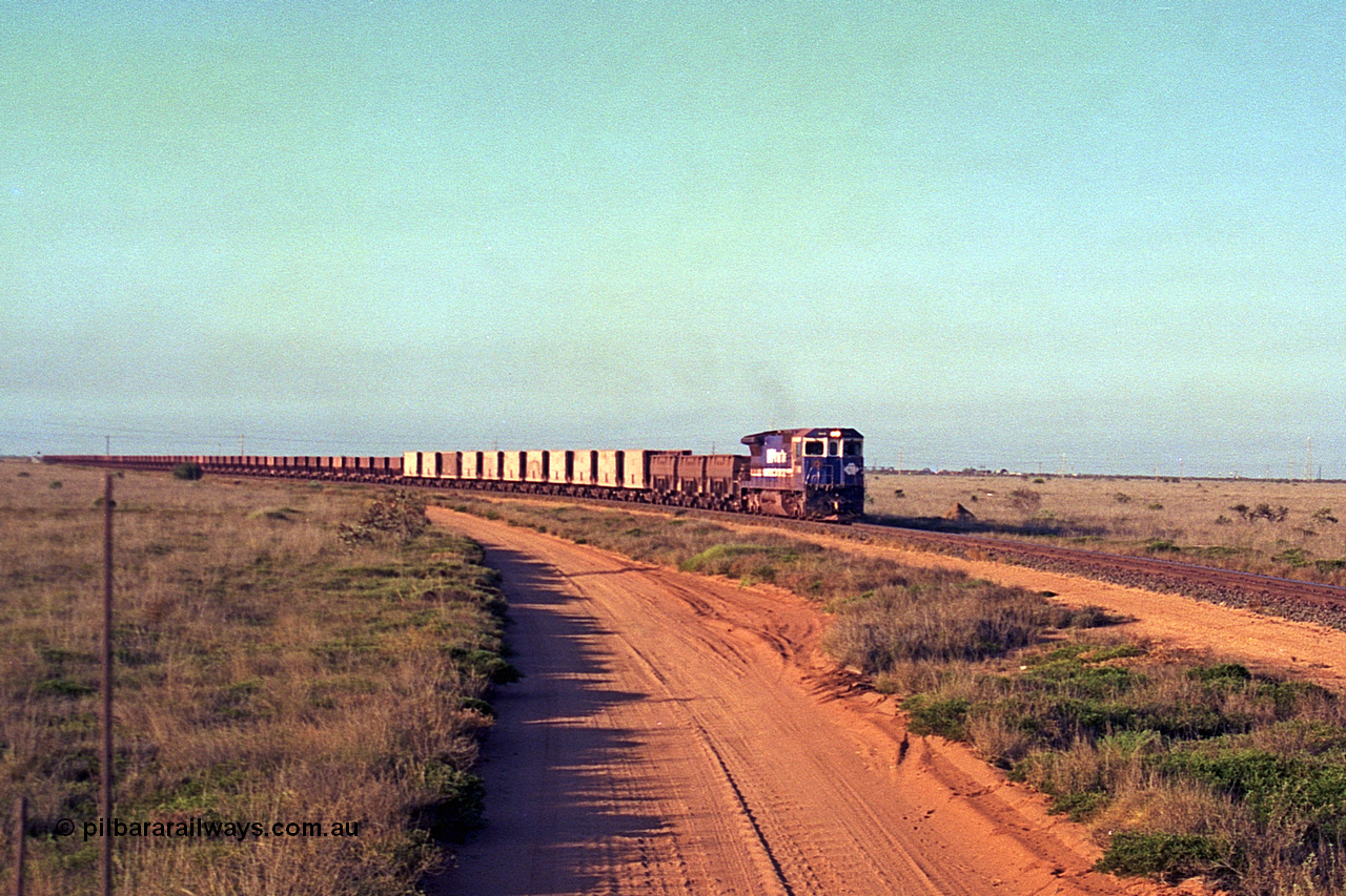 257-24
Goldsworthy Junction, an empty train runs between the junction and the Broome Rd crossing behind the standard single locomotive 5646 'White Springs', a Goninan 1992 built GE CM40-8 model with serial number 5244-11 / 92-135. Late 2001.
Keywords: 5646;Goninan;GE;CM40-8;8244-11/92-135;