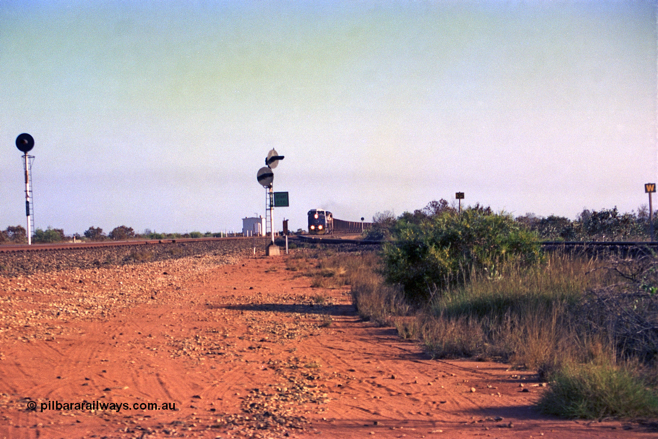 257-29
Goldsworthy Junction looking north as an empty train approaches, the line curving in from the right in the Goldsworthy or Yarrie line. The dual searchlight signal is GJ 9 and is so positioned to allow approaching trains to see the junction signal, like a repeater. Late 2001.

