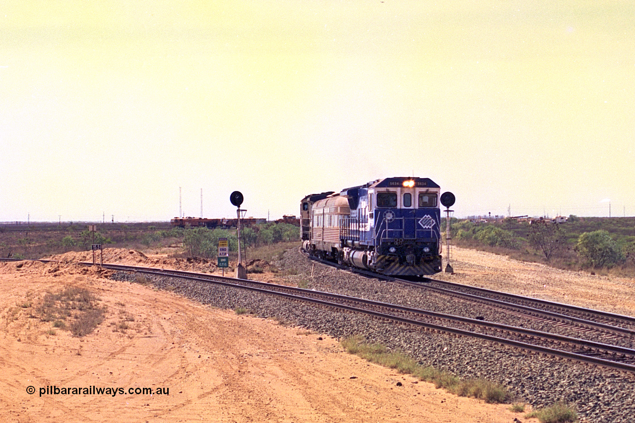 267-18
Goldsworthy Junction, the Sundowner Special is on the Newman mainline leg of the Goldsworthy Junction and triangle, with the Sundowner coach in between CM40-8M GE unit 5634 'Boodarie' serial number 8151-07 / 91-120 and sister CM40-8M 5653. This train, and the empty before it, were delayed due to a jamming switch for the transfer road where Tamper 2 and Ballast Regulator 31 can be seen holding track. The road curving around to the left is the Goldsworthy mainline to Boodarie and Finucane Island. Friday 12th of April 2002.
Keywords: 5634;Goninan;GE;CM40-8M;8151-07/91-120;rebuild;AE-Goodwin;ALCo;C636;5457;G6027-1;