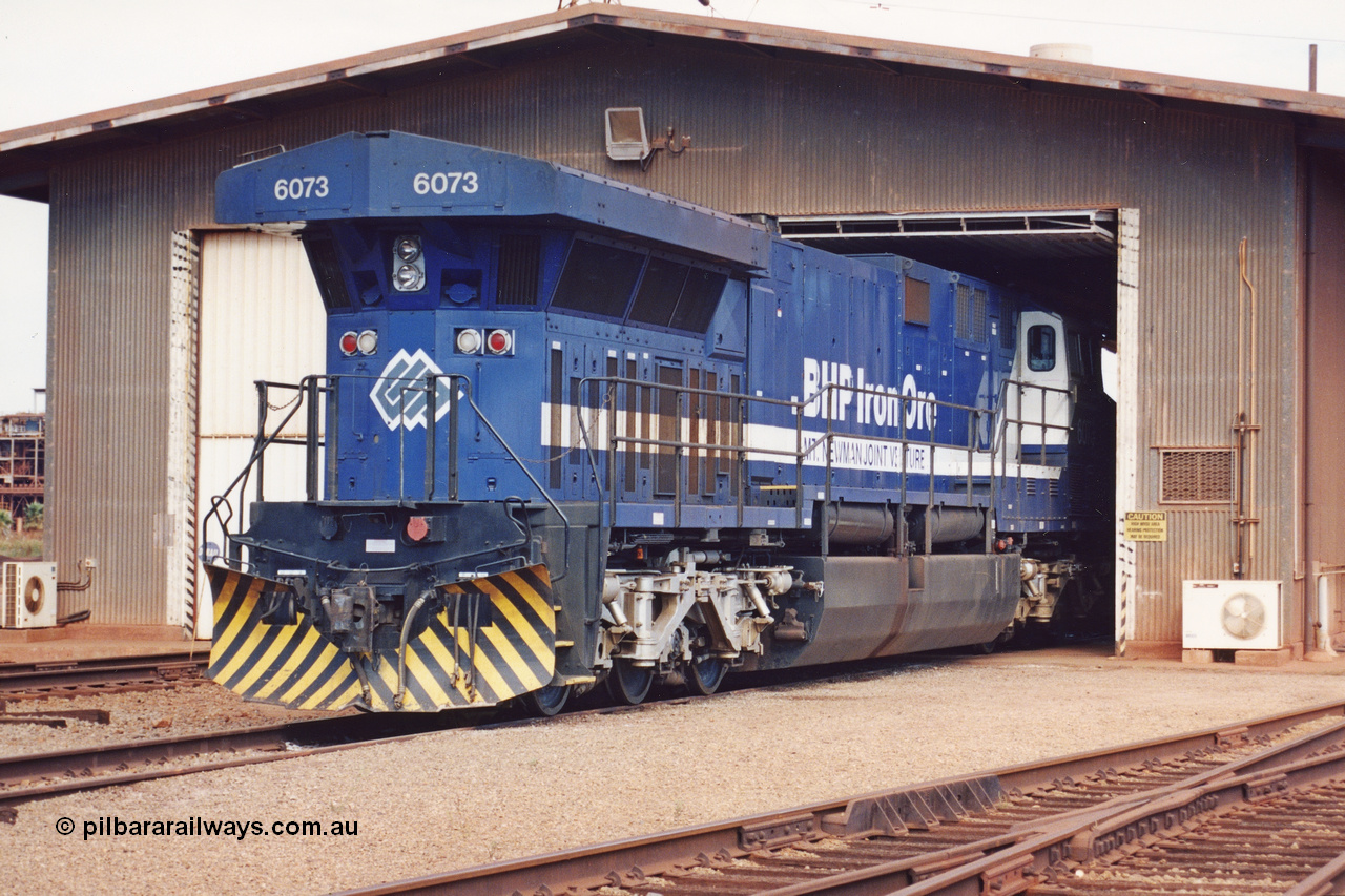 283-05
Nelson Point, BHP wheel lathe sees BHP's big GE AC6000 unit 6073 'Fortescue' serial number 51065 on shed having wheel attention to the leading bogie. May 2002.
Keywords: 6073;GE;AC6000;51065;