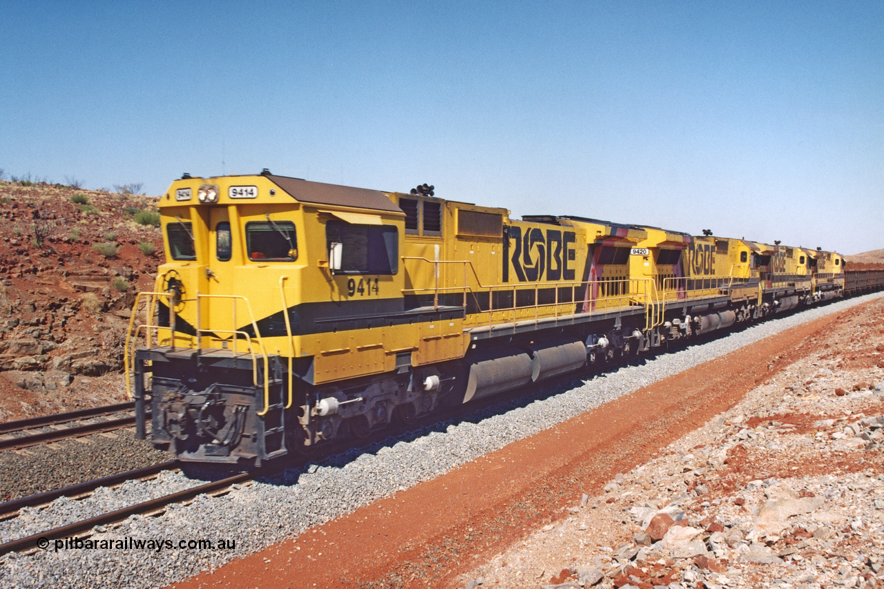 283-22
Harding Siding, quad Robe River CM40-8M units all rebuilt by Goninan from various ALCo models show their tank and bogie differences here. 9414, 9420, 9410 and 9425 lead 202 loaded ore waggons at Siding 1 (Harding). The siding has recently been renamed Harding and extended at the north end to accommodate the new West Angelas trains of up to 240 waggons. Wednesday 22nd May 2002.
Keywords: 9414;Goninan;GE;CM40-8M;8206-11/91-124;rebuild;AE-Goodwin;ALCo;M636;G6060-5;