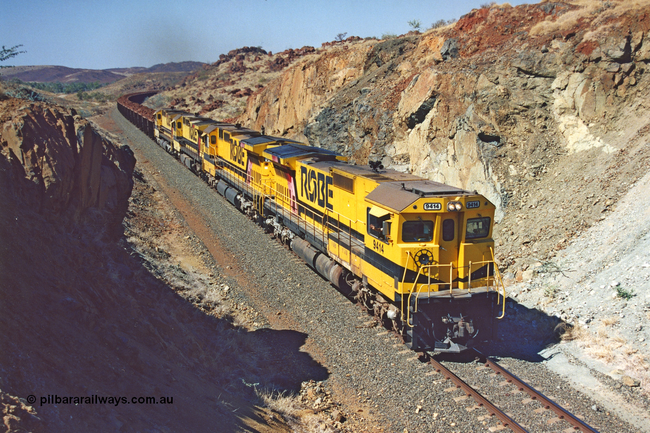 283-33
Near Woodbrook as quad Robe River CM40-8M units 9414, 9420, 9410 and 9525 work a loaded 202 waggons bound for Cape Lambert as they power through the cutting up a short grade at the 37.5 km pipe bridge. 9414 with serial number 8206-11 / 91-124 was rebuilt by Goninan in 1991 from AE Goodwin built M636 ALCo model with original serial number G-6060-5 from 1971. 22nd of May 2002.
Keywords: 9414;Goninan;GE;CM40-8M;8206-11/91-124;rebuild;AE-Goodwin;ALCo;M636;G6060-5;