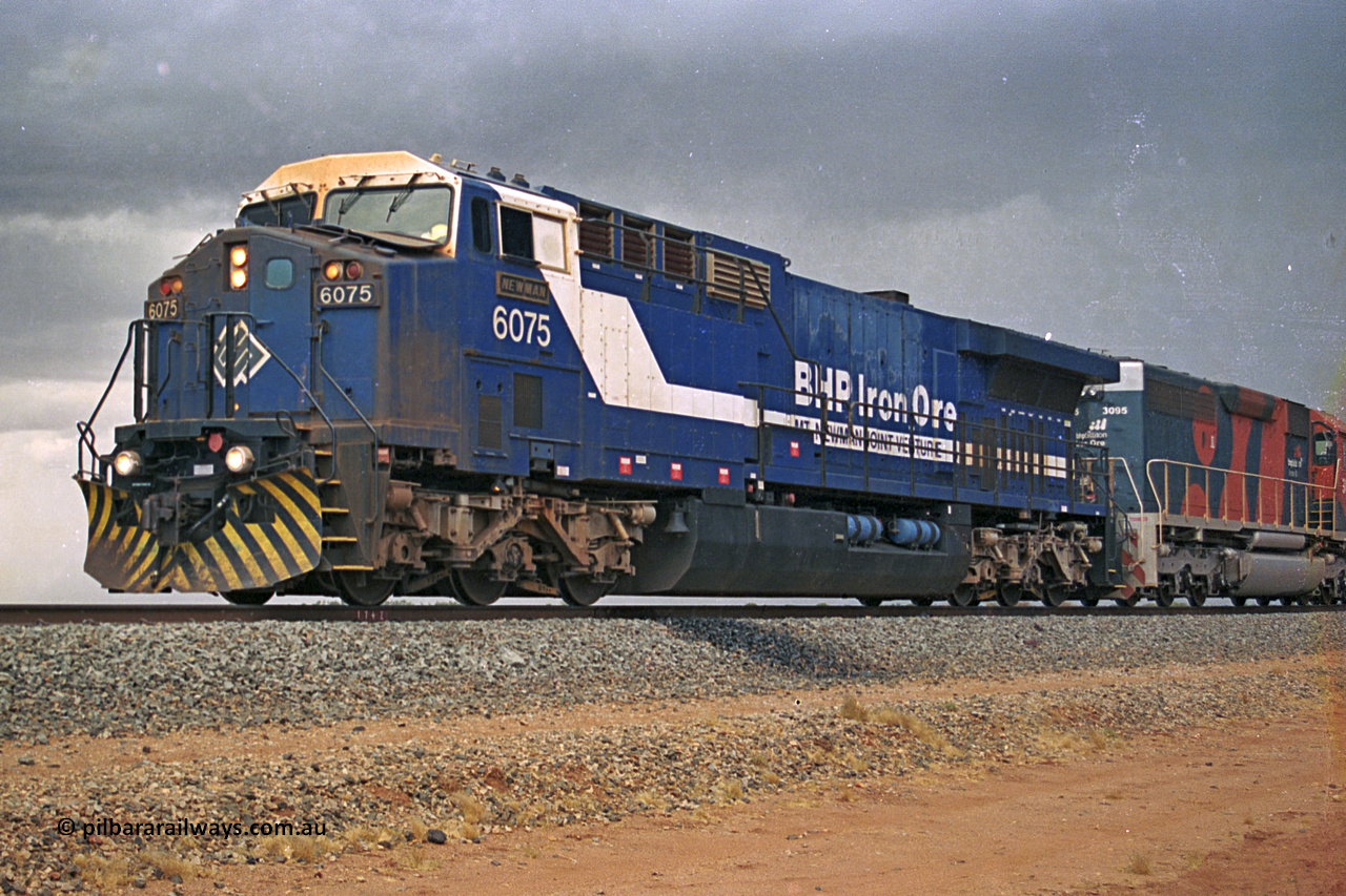 284-37
Bing Siding, 18 km south of Nelson Point and BHP's GE built AC6000 unit 6075 'Newman', serial number 51097, holds the mainline with a loaded train and EMD SD40R unit 3095 as second unit. Late 2004.
Keywords: 6075;GE;AC6000;51067;